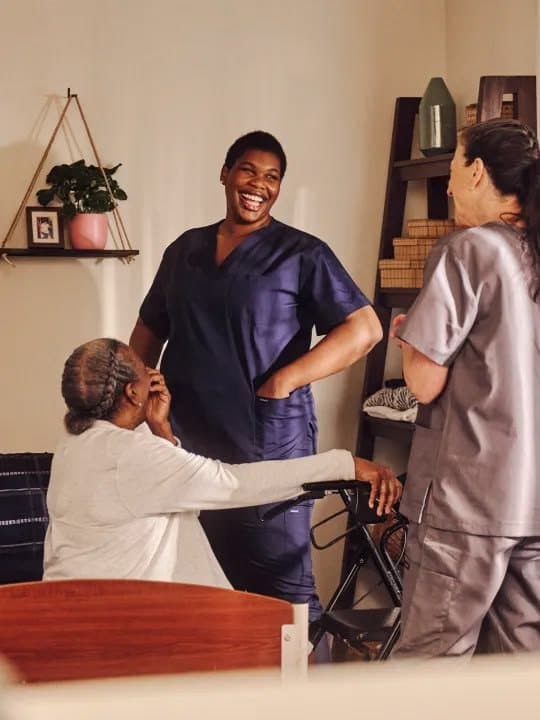 Smiling Rising Angels caregiver supporting an older woman at home
